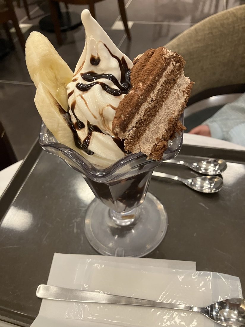 チョコソースとバナナ、ティラミスがのったソフトクリームのパフェ。スプーンが3本