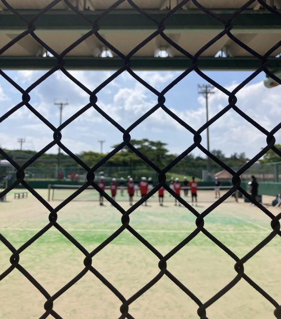 フェンス越しに見た部活の大会のコート
